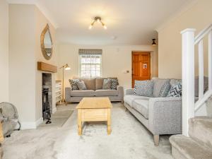 a living room with two couches and a table at The Malt House- Uk34817 in Tattershall