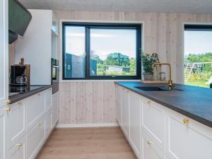 Una cocina con gabinetes blancos y una ventana grande. en 16 person holiday home in Glesborg, en Glesborg 23 fotos más