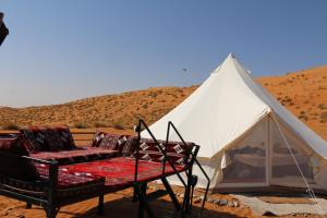 a tent with a couch in the desert at Just For You Starwatching Tent in Al Wāşil
