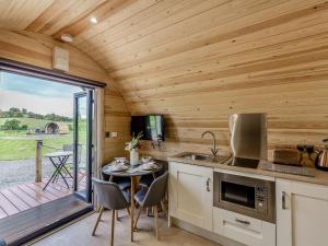 a kitchen with a table and chairs in a tiny house at Beech Uk36260 in Llanfair Caereinion