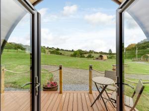 a view from the deck of a home with a glass door at Beech Uk36260 in Llanfair Caereinion