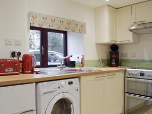 a kitchen with a sink and a washing machine at Southview in Porchfield
