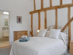 a bedroom with a white bed with shoes on it at The Hop Cottage in Ashperton +11 photos