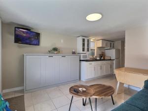 a kitchen with white cabinets and a table at Beach Road - Bari in Siesta Key