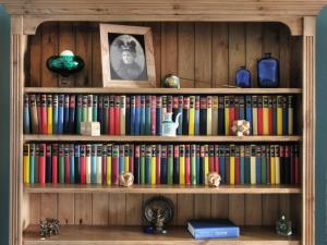 Una estantería llena de libros de diferentes colores. en Bram's View, en Whitby