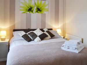 una camera con letto bianco e cuscini di 4 Eldin Hall Cottages a Cayton