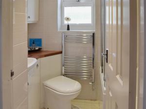 bagno bianco con servizi igienici e finestra di 4 Eldin Hall Cottages a Cayton
