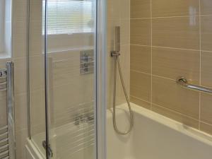 un bagno con doccia con porta in vetro di 4 Eldin Hall Cottages a Cayton