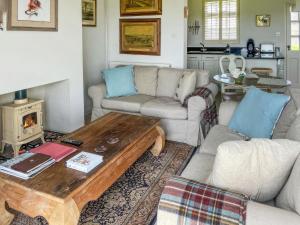 ein Wohnzimmer mit Sofa und Tisch in der Unterkunft Snooty Fox Cottage in Hexham