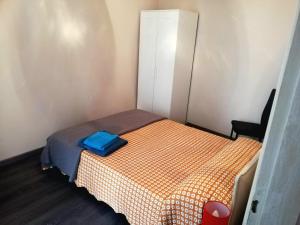 a small bedroom with a bed with a blue bag on it at Da Alessandro in Biella