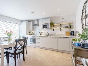 ウィットビーにあるPannett Placeの白いキャビネットとテーブルと椅子のあるキッチン +14枚の写真