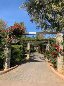 a brick walkway with red flowers and a bridge at Caravelle Camping Village in Ceriale