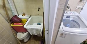 y baño pequeño con aseo y lavadora. en Boa Localização - Wi-fi - Pitangueiras, en Guarujá 12 fotos más