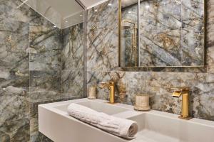 a bathroom with a sink and a tub with a mirror at Superb air-conditioned flat on the Champs Elysées in Paris