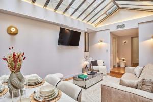 a living room with white furniture and a skylight at Superb air-conditioned flat on the Champs Elysées in Paris