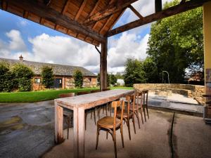 エルゼにあるVilla with Spa, Luxembourgのパティオにある木製のテーブルと椅子