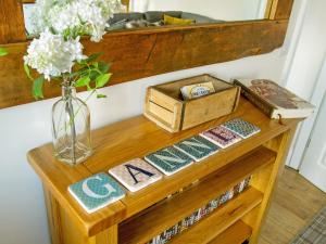 a wooden table with a vase of flowers and a drawer at Gannet Lodge - Uk30977 in Bempton