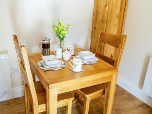 a wooden table with plates and cups on it at Gannet Lodge - Uk30977 in Bempton +10 photos