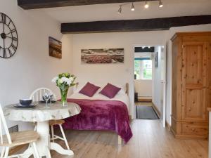 a bedroom with a bed with purple sheets and a table at Weavers Houses - Uk12796 in Hayfield