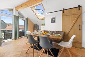 a dining room with a wooden table and chairs at BALANCED Eurasburg Apartments, vollausgestatte Ferienwohnungen auf dem Land in Eurasburg