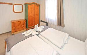 a bedroom with a bed with white sheets and a dresser at Fh Grün in Warenthin