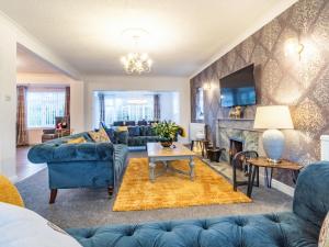 a living room with blue couches and a fireplace at The Gables in Sewerby +28 photos
