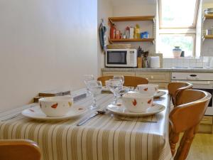 a dining room table with plates and wine glasses at Bryn Gefeiliau in Capel-Curig