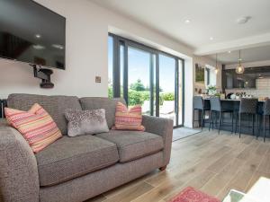 a living room with a couch with pillows on it at Brook Cottage-Uk44378 in Washford