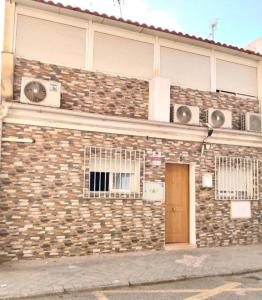 a brick building with a door on the side of it at Alojamiento de habitaciones Zaidín in Granada