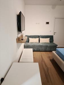 a living room with a couch and a tv at NOLO Rooms and Suites in Durrës