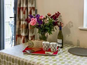a table with a plate of flowers and a bottle of wine at The Bothy in Bradworthy