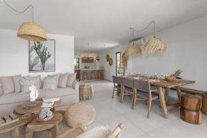 a living room with a white couch and a table at Villa Baya in Oyster Pond