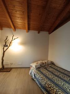 a bedroom with a bed in a room with wooden ceilings at La Casetta Rosa in San Venanzo