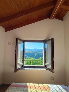 a bedroom with a large window with a view at La Casetta Rosa in San Venanzo