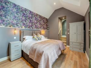 a bedroom with a large bed with a floral accent wall at Ling At Holly House - Uk44468 in Newton
