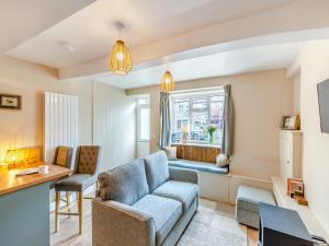 a living room with a couch and a window at Duckling Cottage in Addingham