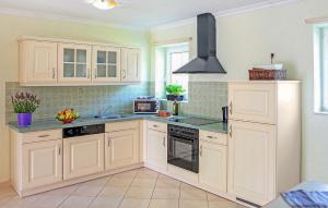 a kitchen with white cabinets and a stove top oven at Ferienhaus Verchen in Verchen
