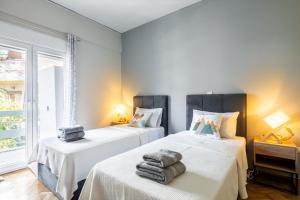 deux lits dans une chambre avec des serviettes dessus dans l'établissement HELIOS sunny comfortable apartment, à Athènes