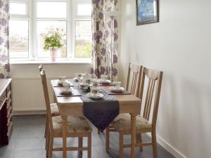 a dining room table with chairs and a table cloth on it at Rossall Beach Cottage in Cleveleys