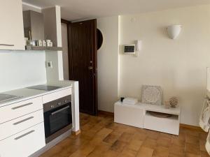 a kitchen with white cabinets and a black oven at Suite Incanto lago di Garda in Torri del Benaco