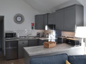 a kitchen with gray cabinets and a counter top at Little Tregarthen in Padstow