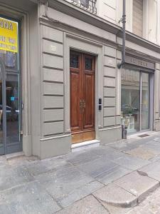 a store front with a wooden door on a city street at Casa Valentino - Stay in the heart of Asti in Asti