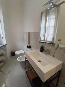 a bathroom with a white sink and a toilet at Casa Valentino - Stay in the heart of Asti in Asti +7 photos