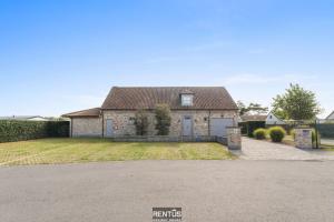 a brick house with a yard with a driveway at Villa Hoge Duin - spacious luxury villa with large garden in Koksijde