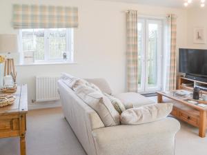 ein Wohnzimmer mit Sofa und Fernseher in der Unterkunft Good Tides in Beadnell