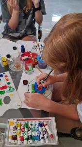 a young girl painting a cake with a paintbrush at NovART Gallery & Sea Hotel in Sumqayyt
