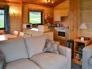 ein Wohnzimmer mit Couch und Küche in der Unterkunft Lodge 59 in Woolfardisworthy