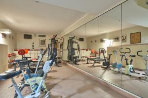 een fitnessruimte met diverse loopbanden en een spiegel bij Hotel Careni Villa Italia in Finale Ligure