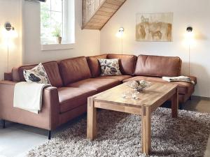 a brown couch in a living room with a coffee table at 5 star holiday home in Væggerløse in Bøtø By