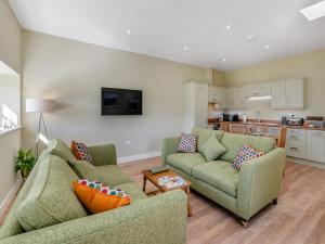 a living room with two couches and a kitchen at Bracken At Holly House - Uk44469 in Newton